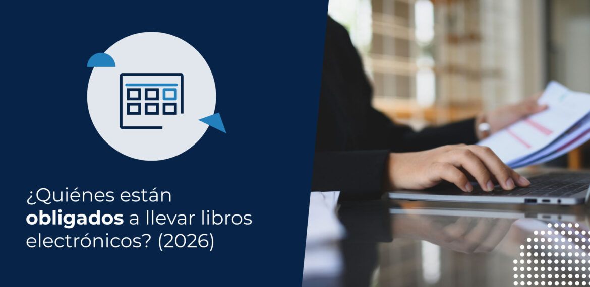 Persona en traje de oficina revisando documentos contables frente a un computador para determinar quiénes están obligados a llevar libros electrónicos.