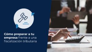 Profesional de contabilidad realizando una fiscalización tributaria mediante el uso de calculadora y revisión de informes financieros en una oficina.