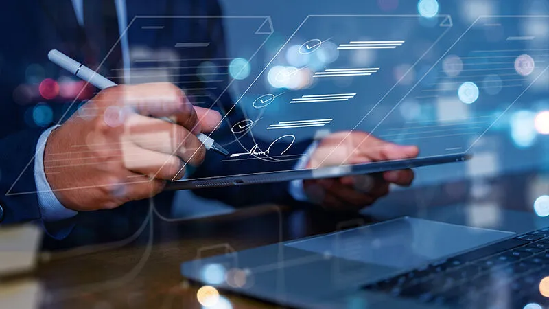 Manos de un hombre firma los documentos de manera digital