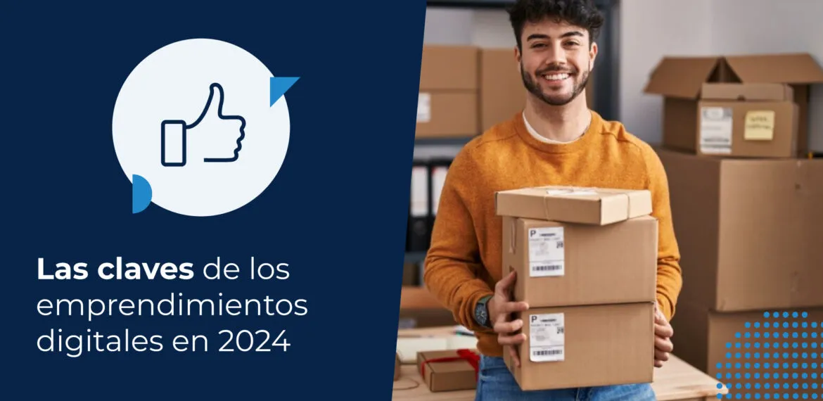 Una persona sonríe con cajas en las manos mientras se apoya en un escritorio que detrás presenta estantes con más cajas de sus emprendimientos.