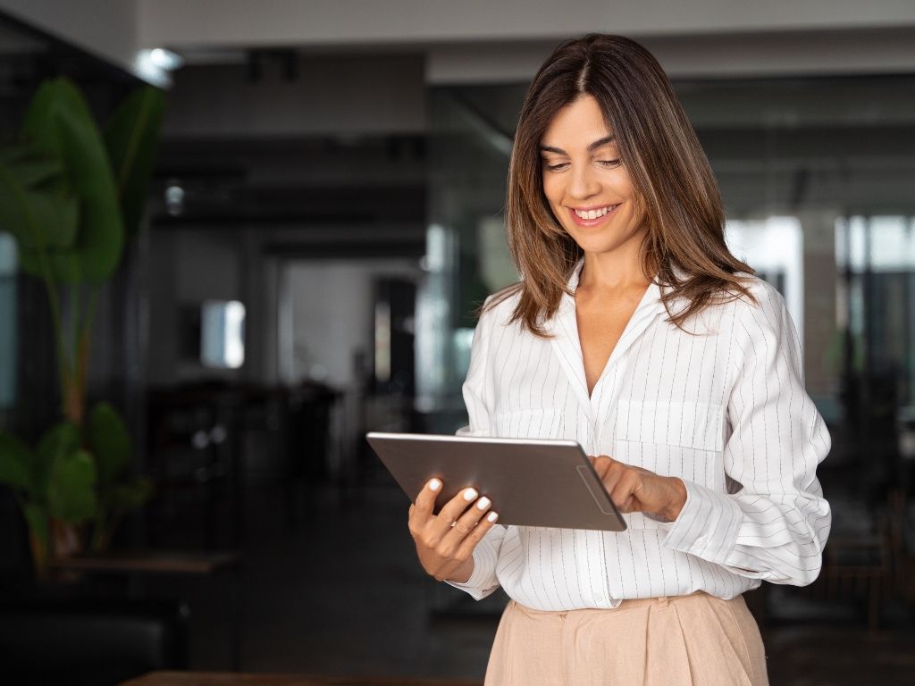 Mujer emprendedora utilizando satisfactoriamente su firma electrónica Acepta by Sovos en su tablet.