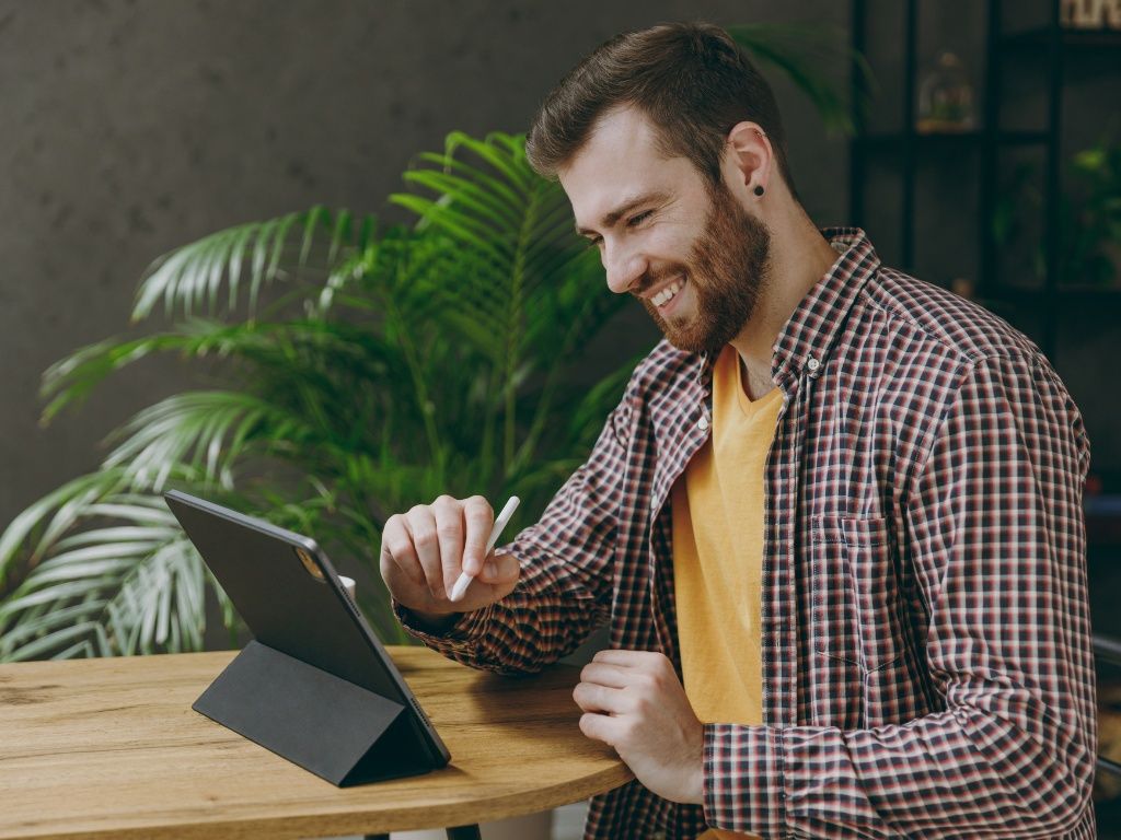 Joven emprendedor frente a su tablet automatizando tareas con su firma electrónica Acepta by Sovos.