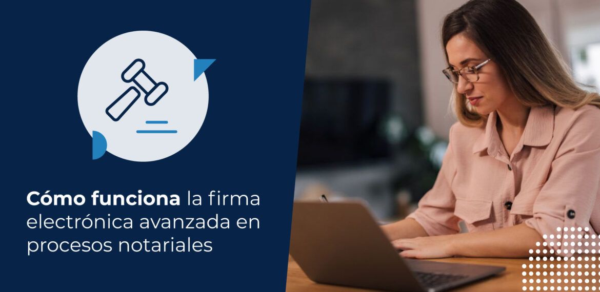 Mujer joven con blusa rosa y lentes trabajando concentrada en su escritorio. Está buscando en su computador cómo funciona la firma electrónica avanzada en notaría.